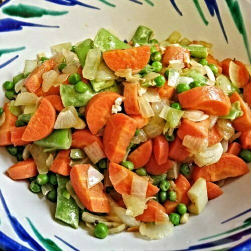 Ingredients for arros caldoso, a bowl of cooked mixed vegetables, with carrots, onion, peas, beans