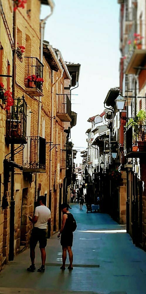 A narrow street scene of Seville with a couple navigating the streets