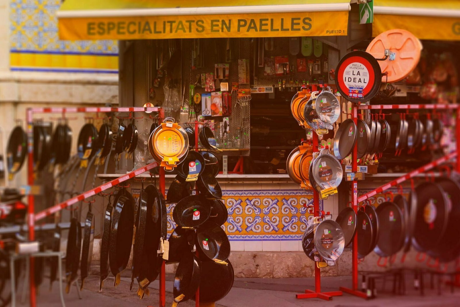 A street scene showing a traditional paella shop selling a rnage of paella pans and cokking items