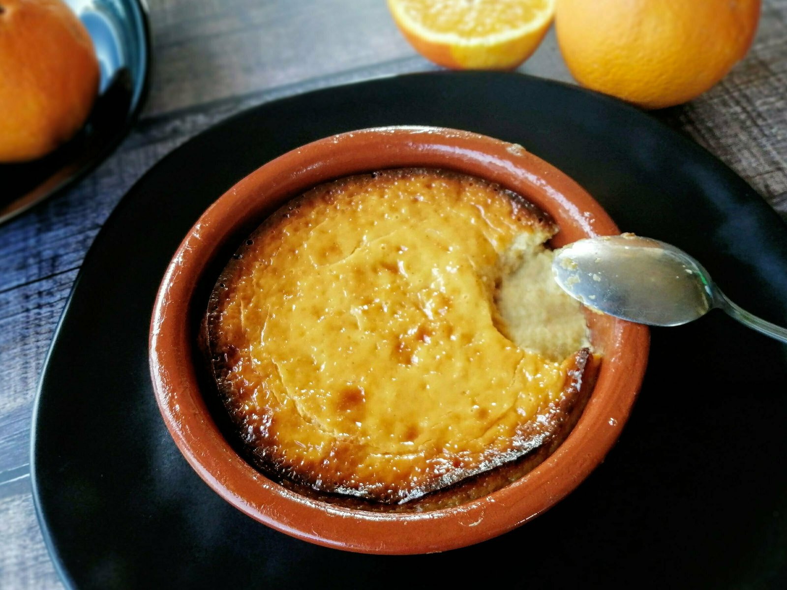 A baked cheesecake with hoey and orange sits on a wooden counter