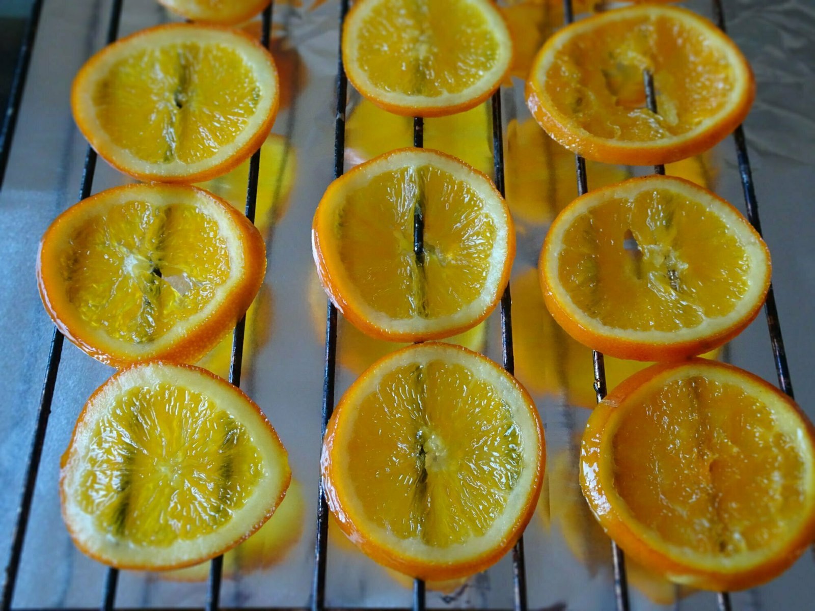 a tray of candied orange slices sit on a counter drying