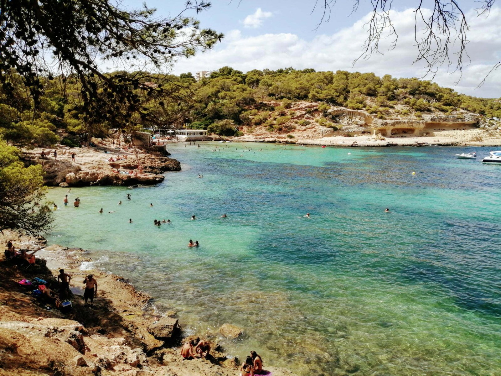 A sweeping scene of Playa del mago, a turquoise beach and golden roacks located in the southern tip near Palma, Mallorca