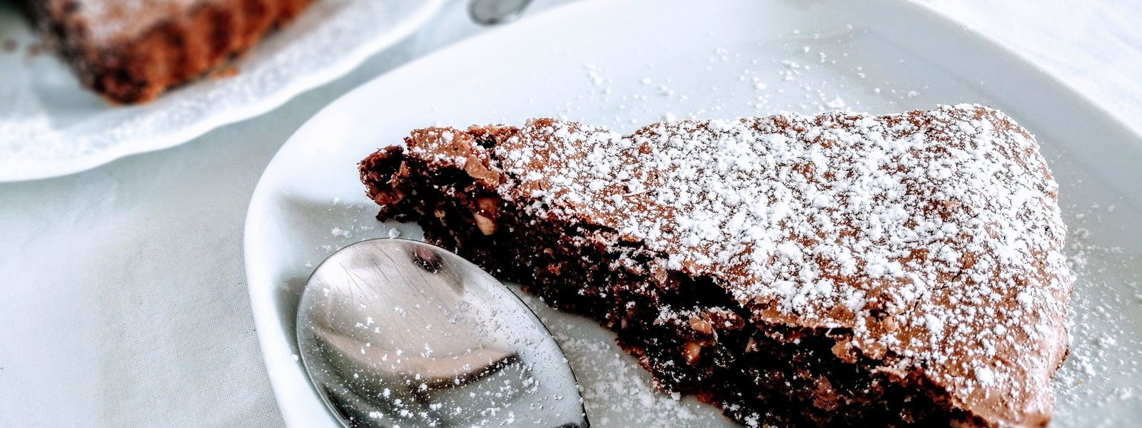 A slice of chocolate hazelnut tart sits on a white plate