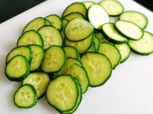 sliced cucumber on a white chopping board