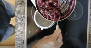 Cherries are strained through a small white sieve