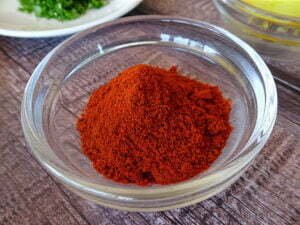 a ramikin sits on a counter filled with bright red ground paprika