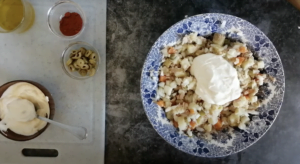 mayonnaise is added to. alrge bowl full of ensalada rusa ingredients