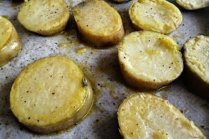 roasted potato scallops sits on parchment paper with olive oil and salt