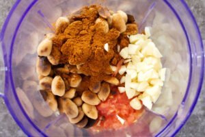 ingredients for romesco sauce sits in. a blender