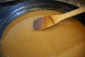 a rich ambber colored salted caramel sits in a frying pan