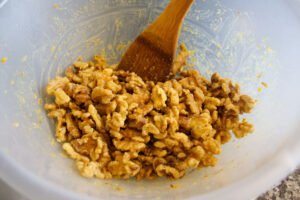 walnuts, orange juice and zest are mixed in a alrge white bowl