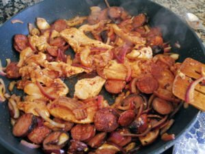 a pan of chocken and chorizo cooks with some onions
