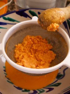 pulp from a salmorejo soup sits in a sieve