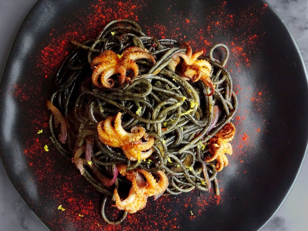 plated squid ink pasta with baby octopus