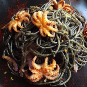 plated squid ink pasta with baby octopus
