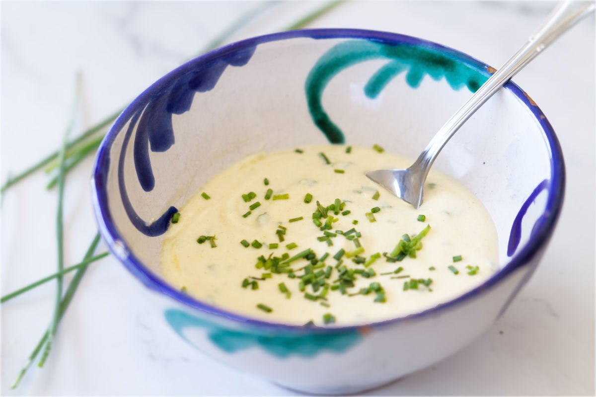 a small bowl of healthy yogurt salad dressing with chives garnishing