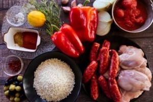 ingredients for making Spanish chicken and rice are laid out on a table