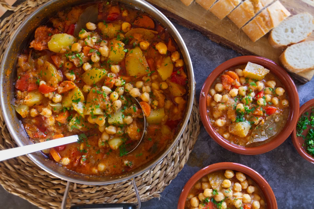 a large pot of chickpea stew (Potaje de Garbanzos) sit waiting to be served into small earthenware bowls