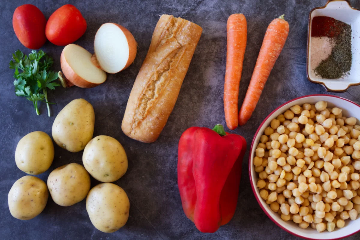ingredients for making Chickpea Stew are laid out on a black marble table