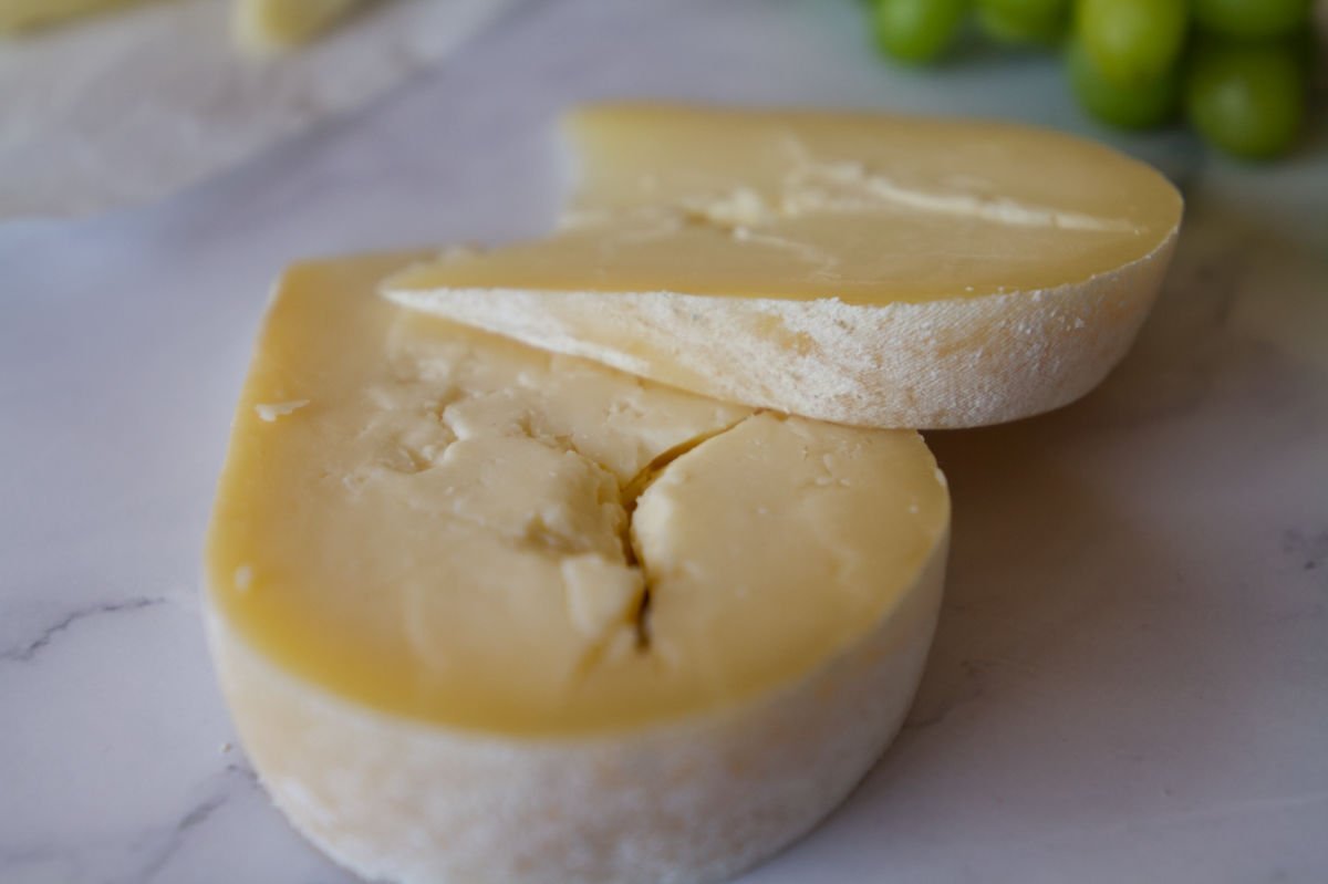 A few slices of Mahon cheese sit on a cheese board