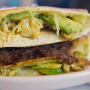 A stack of tortilla breakfast wraps sits on a plate
