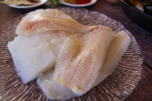 some pieces of white fish sitting on a plate