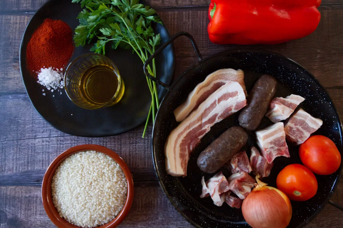 ingredients for making arroz al horno are laid out on a kitchen table