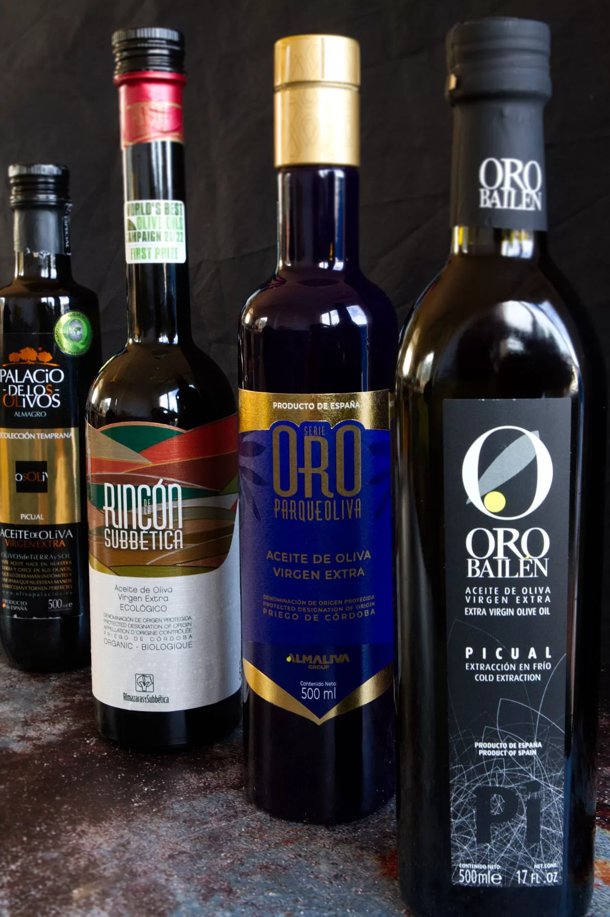 4 award-winning bbottles of extra virgin olive oil arranged on a counter.