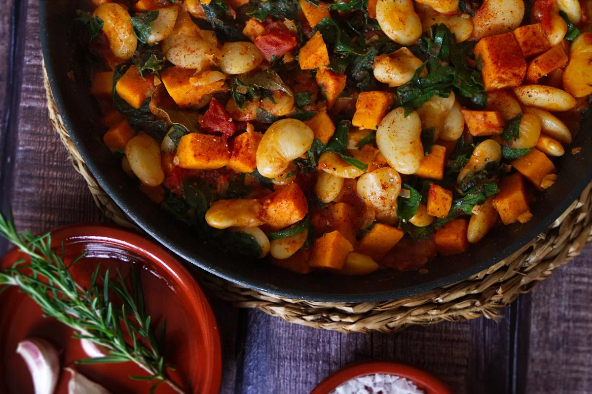 a large pot of smoky butter bean stew with sweet potato and kale