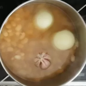 a pot of fabada asturiana is cooking on a stove