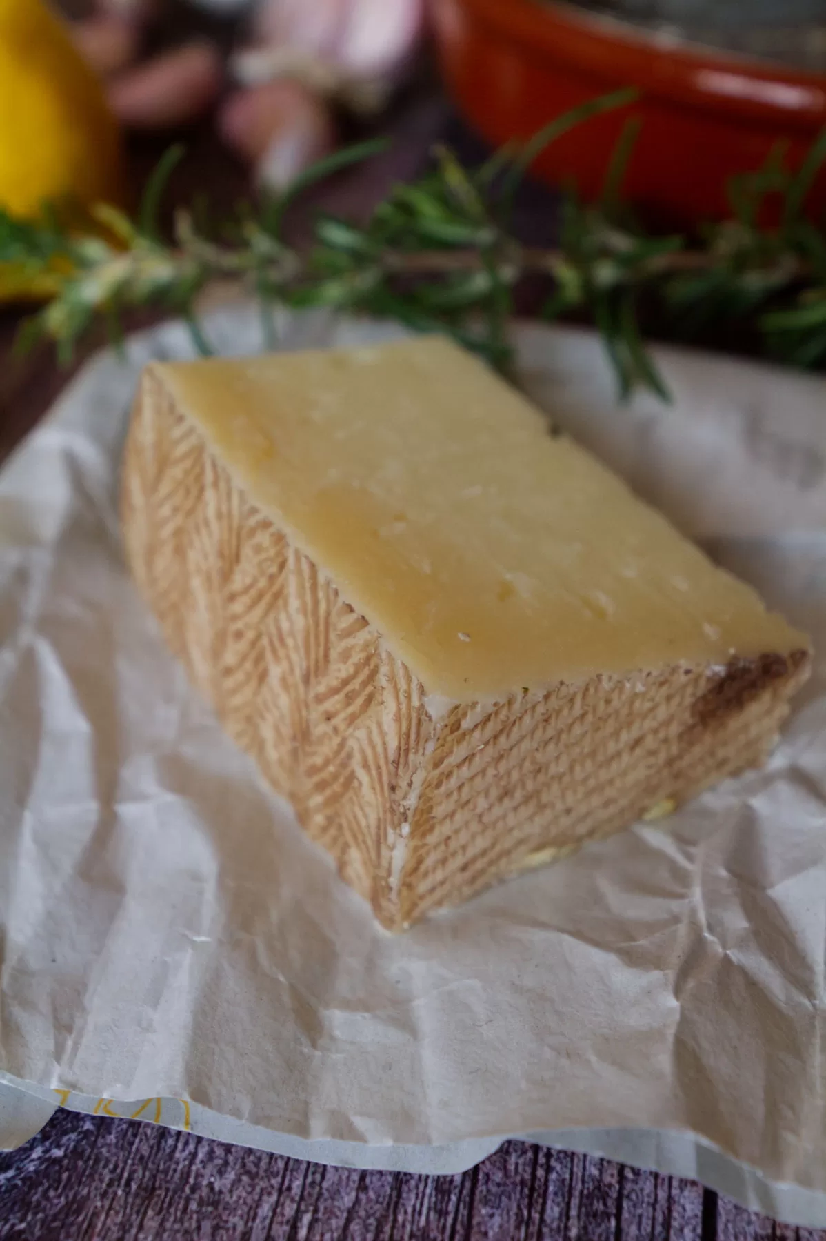 A wedge of Manchego cheese with its distinctive brown wax rind. 