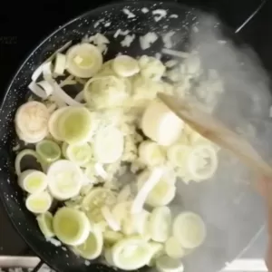 Leeks and onion simmer in a pan