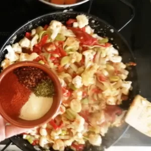 spices are added to a pan of vegetables