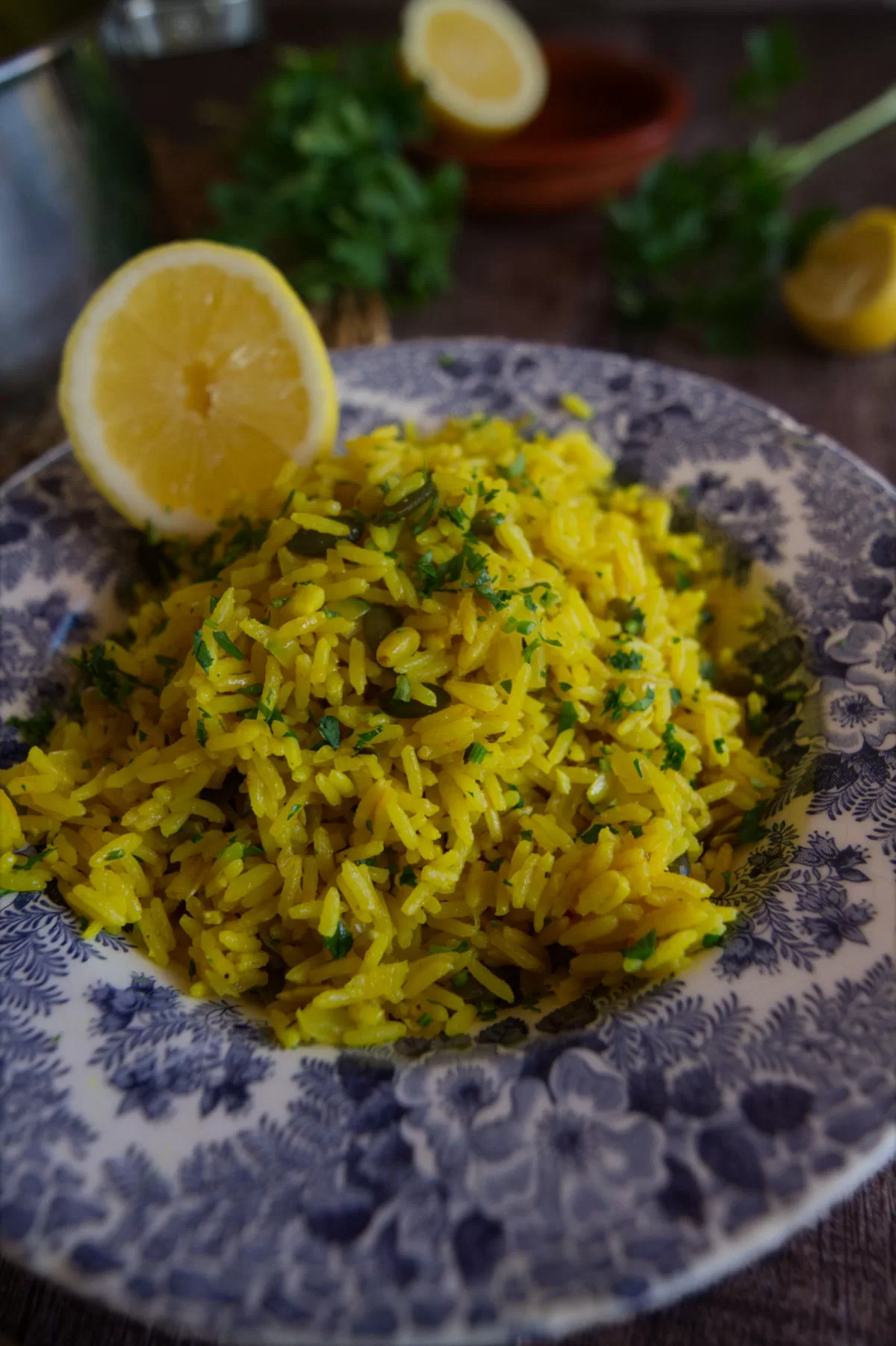 A bowl of Mediterranean yellow rice is served in a decorative bowl. 