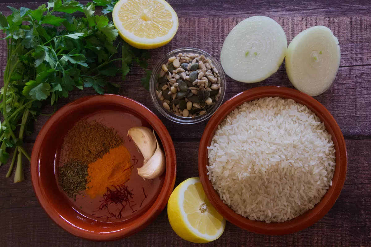 ingredients used to make Mediterranean yellow rice are laid out on a table. 