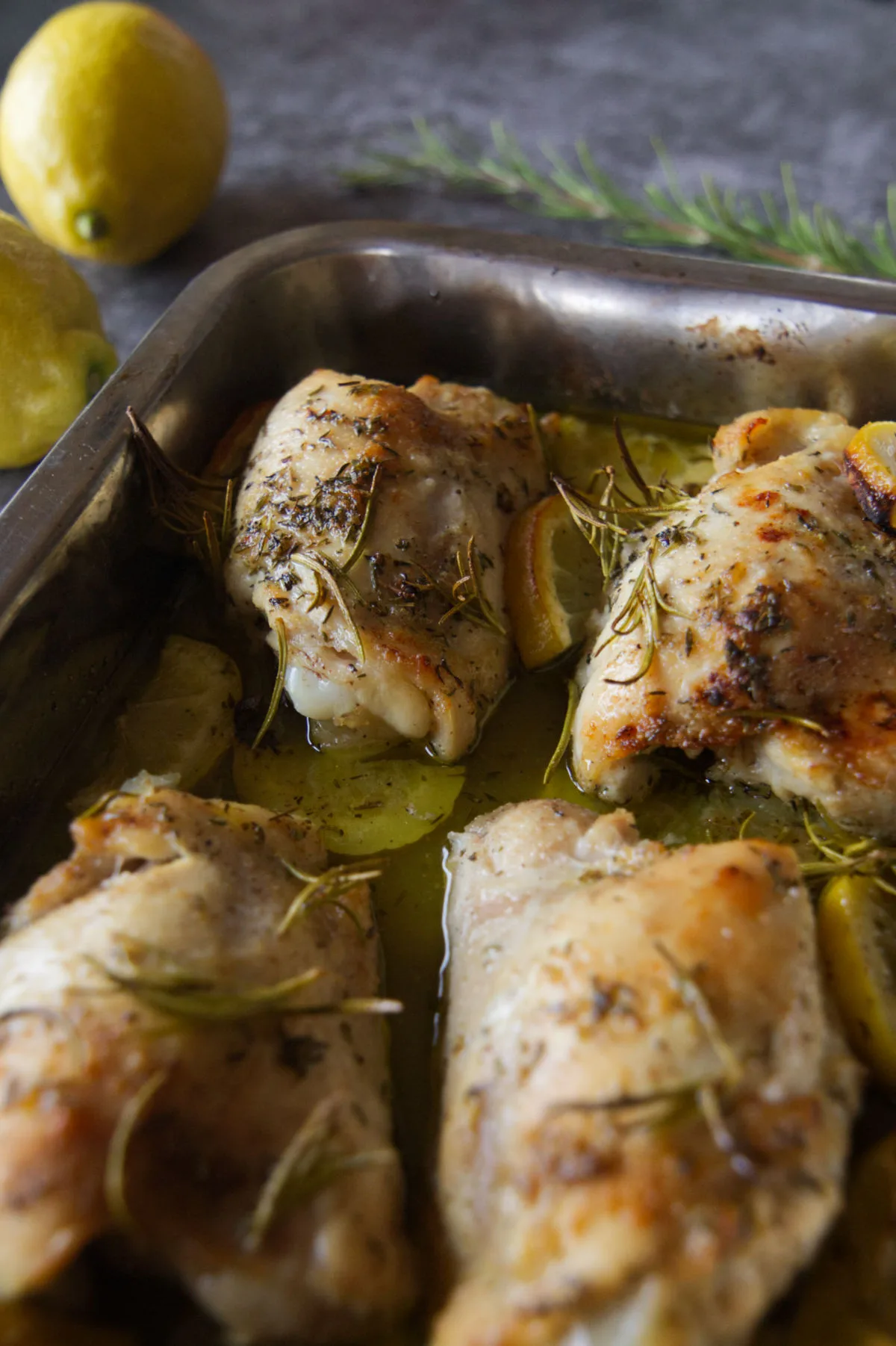 A baking tray of lemon and herb chicken thighs.