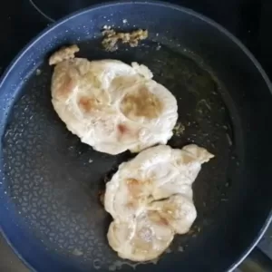 2 pork tenderloins cook in a frying pan.