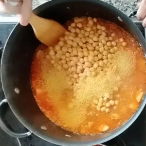 Chickpeas and maravilla pearl pasta are added to a large pot.