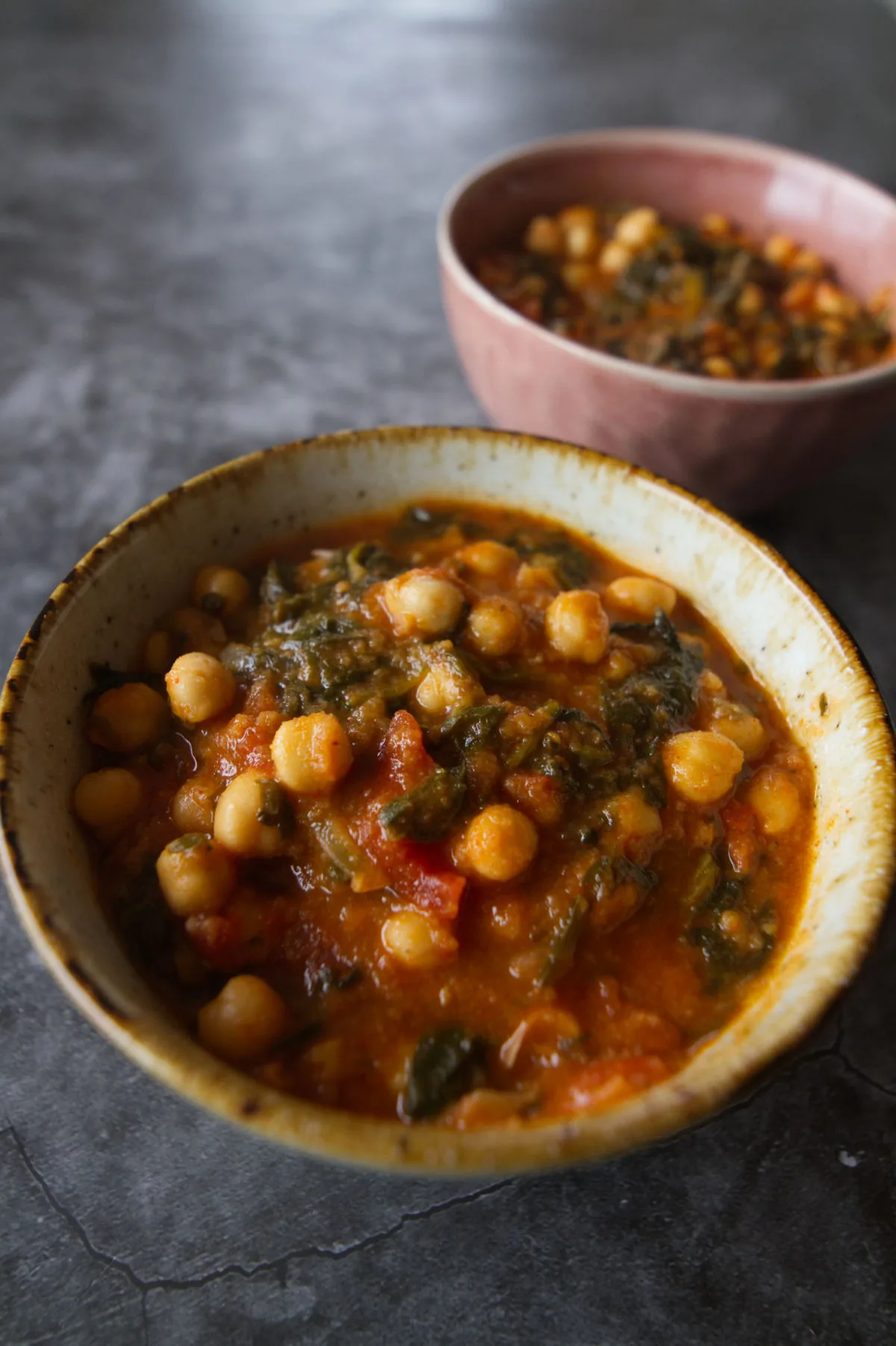 A small bowl of smoky Spanish chorizo stew with spinach and chickpeas.