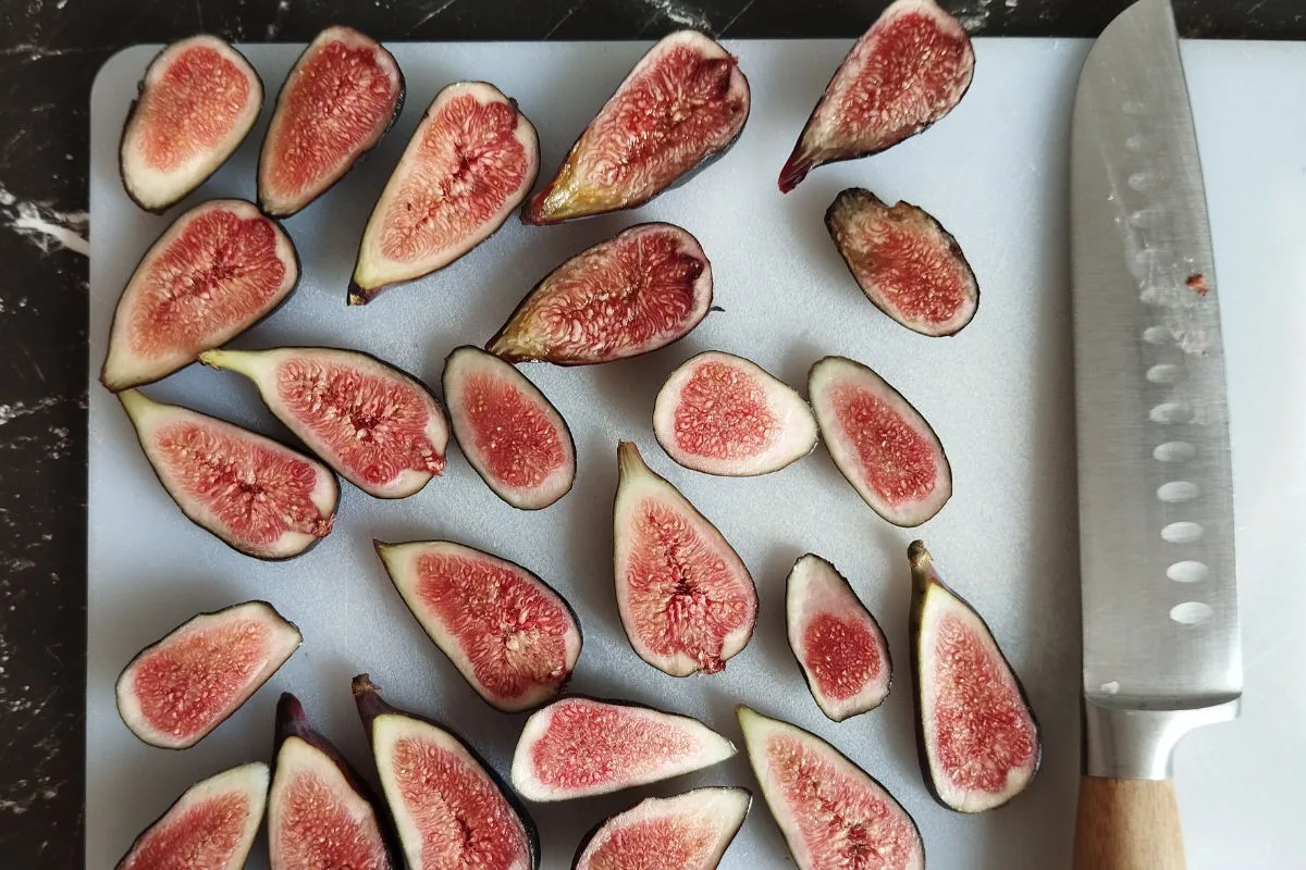 sliced figs are set oout on a chopping board. 