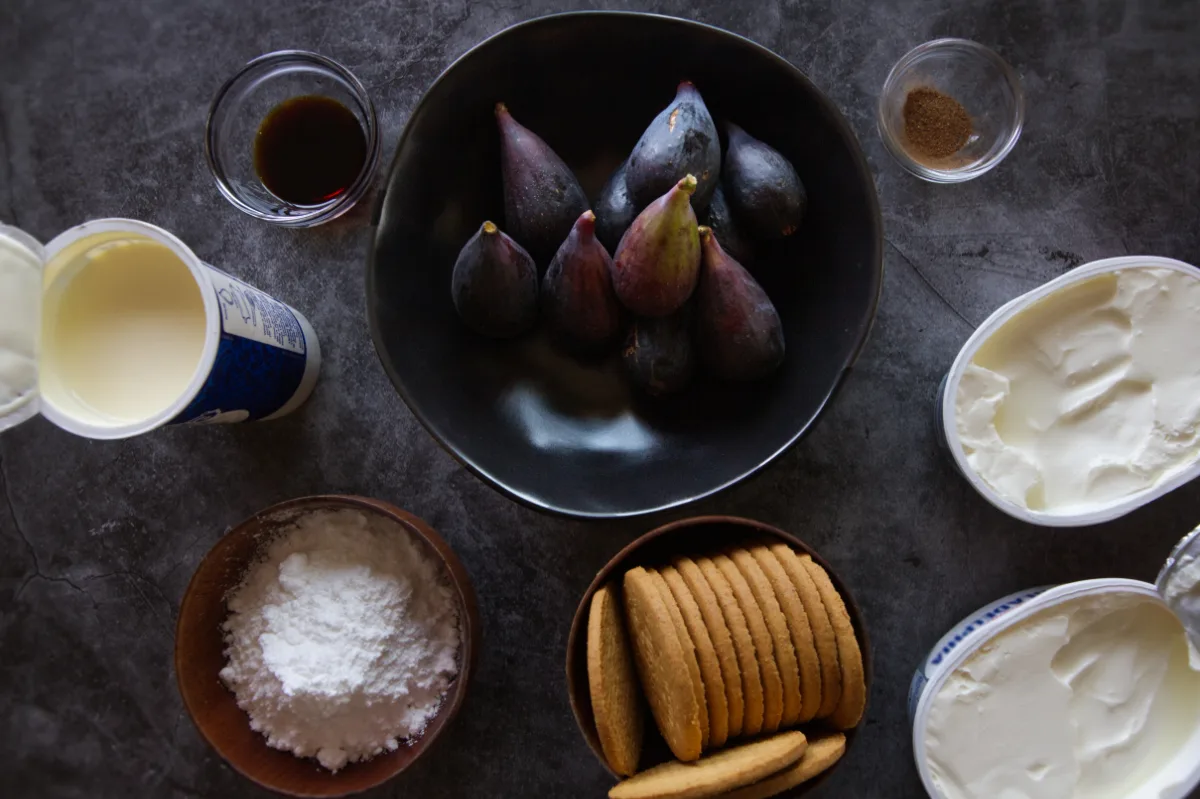 ingredients used to make a fig and vermouth cheesecake sit on a counter. 