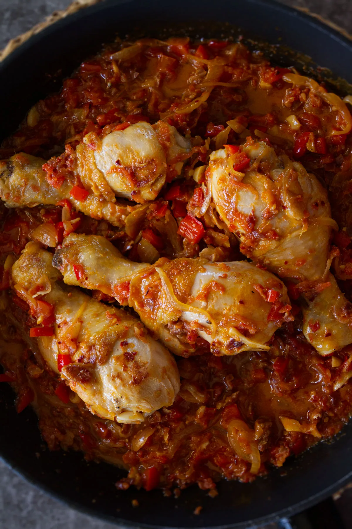 A pan of Spanish chicken chilindron with lots of sauce.