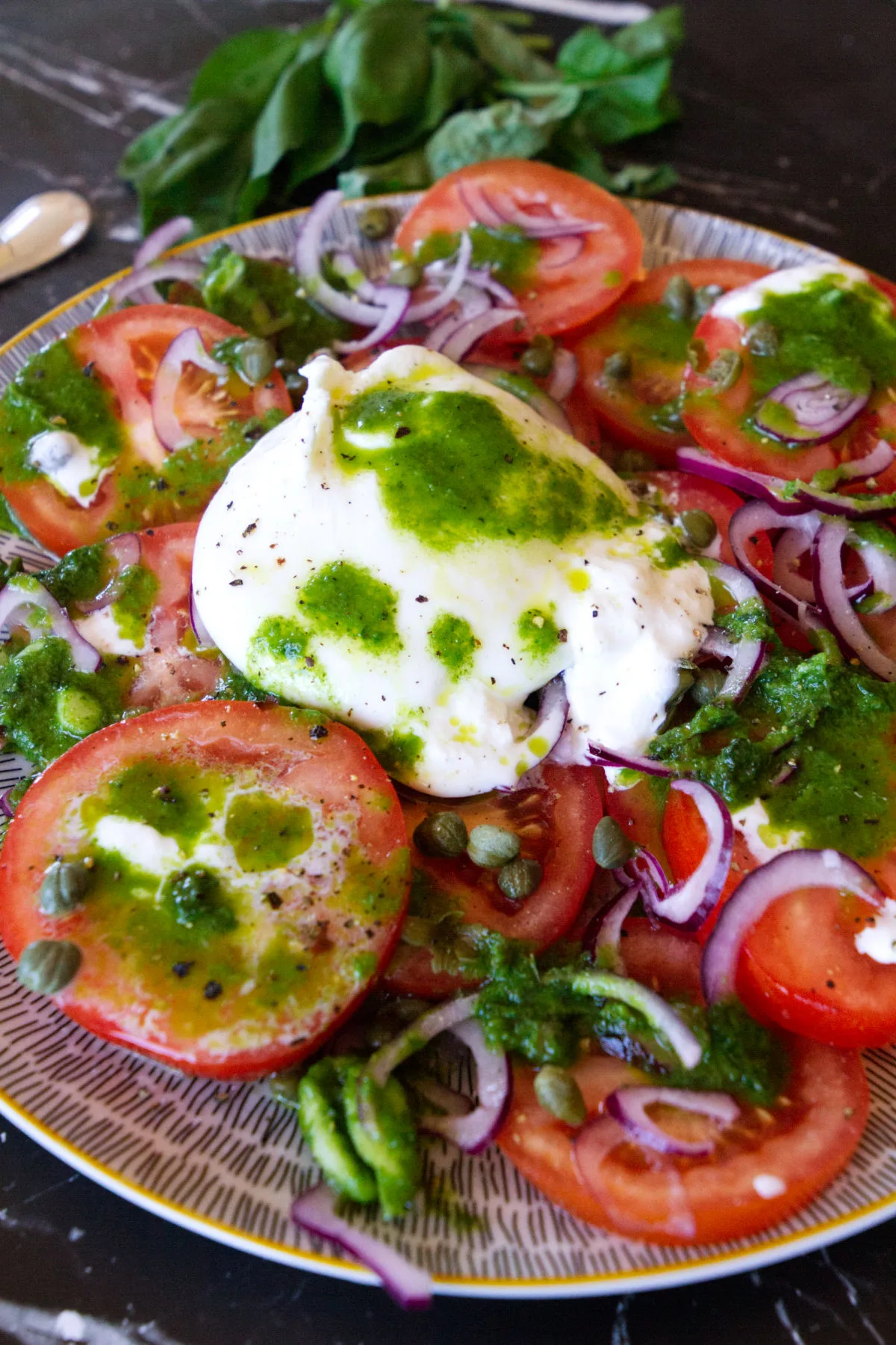 basil and garlic dressing drizzled over a tomato burrata salad. 