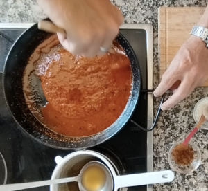 Bravas sauce is stirred in a pan.