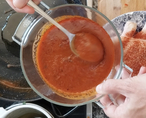 Bravas sauce is added to some oil in a pan.