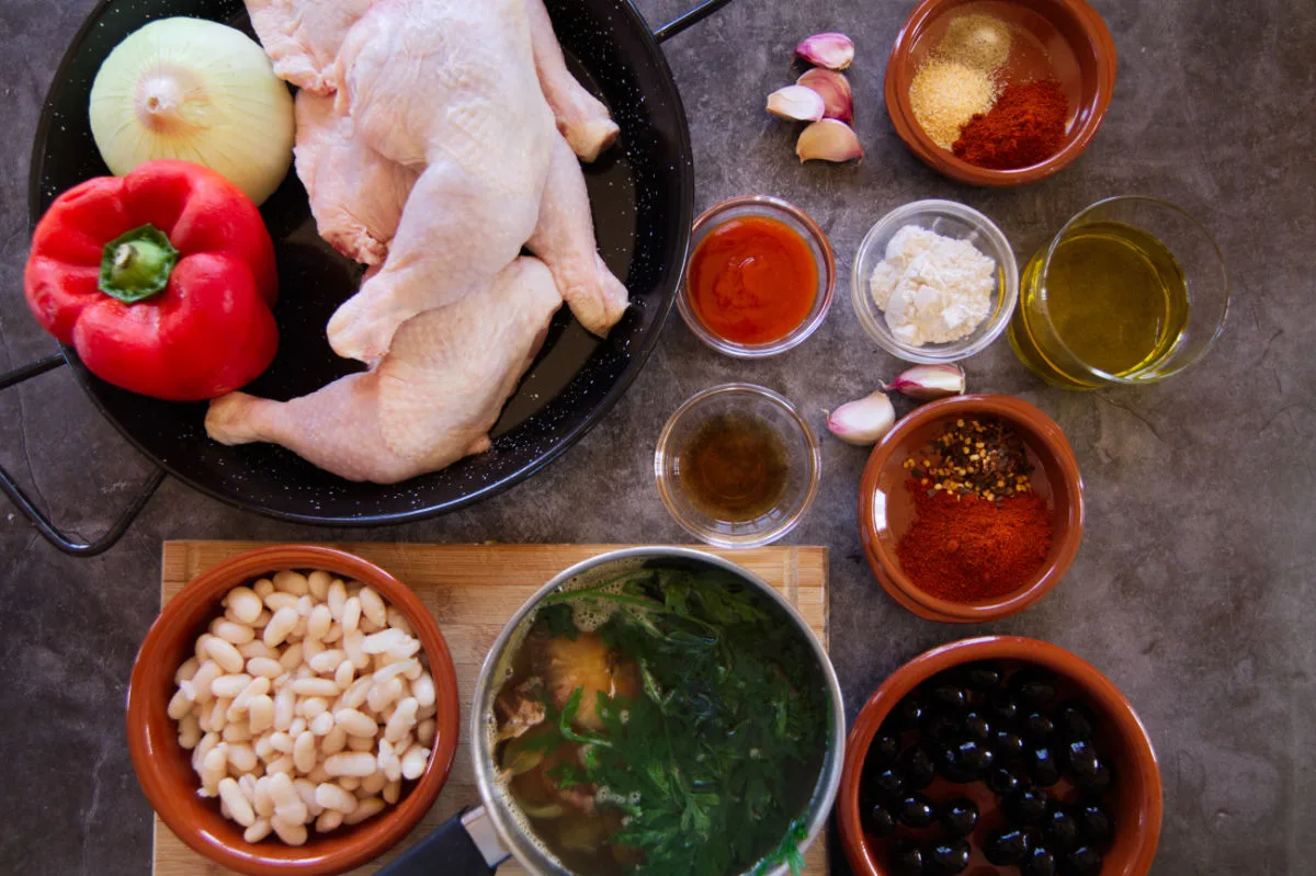 Ingredients used to make Spanish Chicken in a Smoky bravas sauce are laid out on a table.