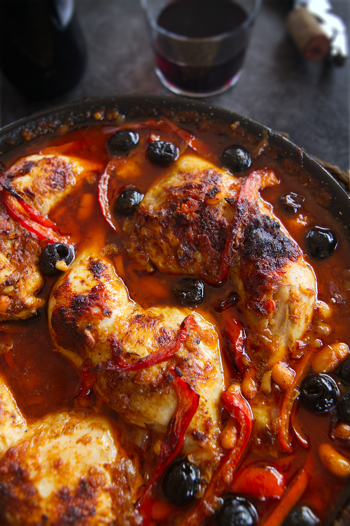 A pan of Spanish chicken with smoky Bravas sauce sits at a table setting.