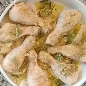 Browned chicken in a pan with some garlic and olive oil