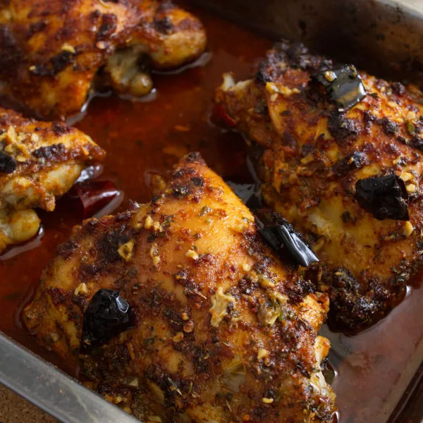 A tray of oven-baked spicy Mediterranean chicken thighs.