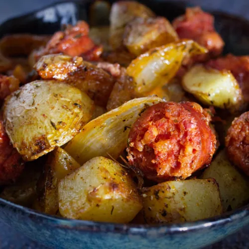 A bowl of roasted potatoes with chorizo and thyme